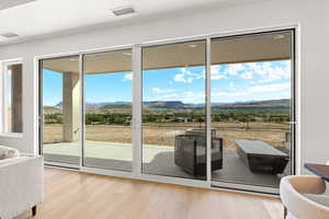 Doorway with a mountain view, wood finished floors, and a baseboard heating unit