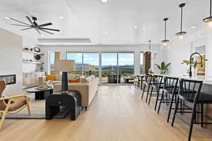 Living area featuring a fireplace, light wood finished floors, recessed lighting, ceiling fan, and a textured ceiling