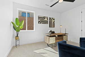 Office area featuring light carpet and a ceiling fan