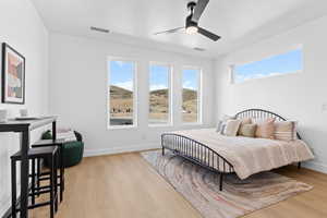Bedroom with light wood-style flooring and a ceiling fan