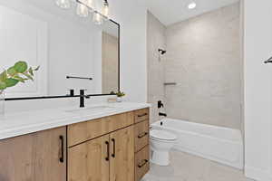Full bath featuring vanity, shower / bathtub combination, light tile patterned flooring, and recessed lighting