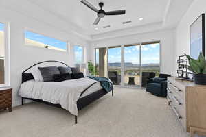 Bedroom featuring light colored carpet, a ceiling fan, a tray ceiling, access to exterior, and recessed lighting