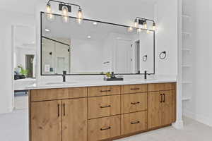 Ensuite bathroom featuring double vanity, a shower stall, recessed lighting, and light tile patterned flooring