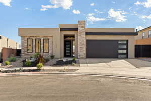 Contemporary house featuring stucco siding, concrete driveway, a garage, and stone siding