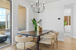 Dining area with light wood-style floors and a chandelier
