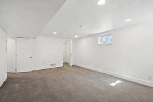 Below grade area with carpet floors, recessed lighting, and a textured ceiling