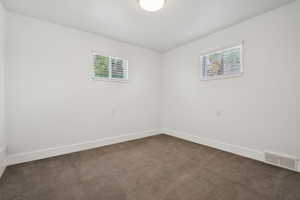 Carpeted spare room with baseboards