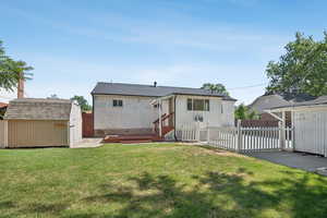Back of property featuring a storage unit, a patio area, and brick siding
