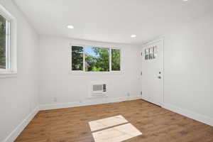 Spare room with recessed lighting, a wall mounted AC, and wood finished floors