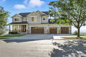 Craftsman inspired home featuring stone siding, concrete driveway, covered porch, a garage, and board and batten siding