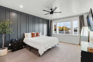 Bedroom featuring light carpet, a decorative wall, recessed lighting, and a ceiling fan