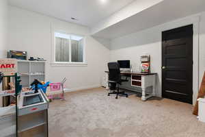 Carpeted bedroom being used as office space featuring baseboards