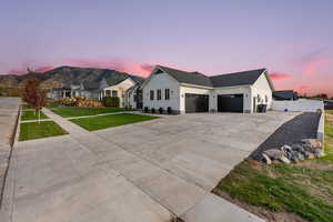 Modern farmhouse style home featuring a garage, driveway, a mountain view, and a gate