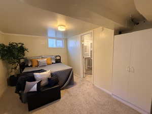 Bedroom featuring light colored carpet and ensuite bath