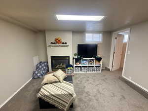 Living area with carpet and a glass covered fireplace