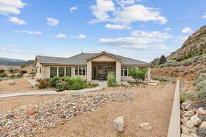 View of front of property featuring a patio area, a tile roof, a mountain view, and stucco siding