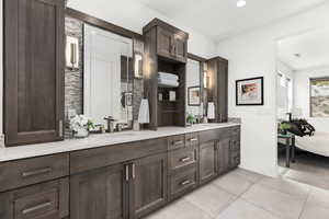 Ensuite bathroom featuring double vanity, tile patterned floors, and recessed lighting