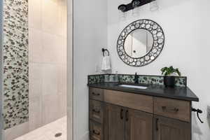 Bathroom featuring vanity and tiled shower