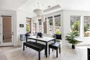 Dining room with a tray ceiling and light tile patterned floors