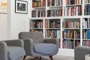 Sitting room featuring wall of books