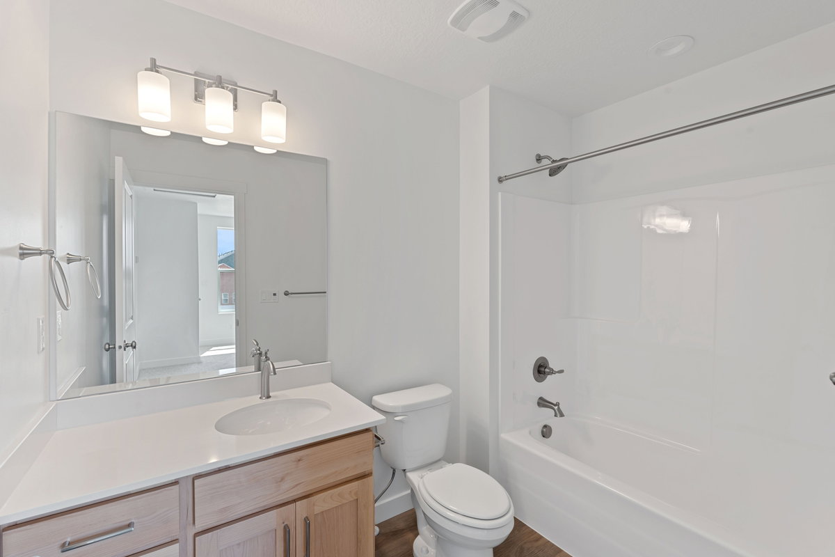 Bathroom with vanity, shower / tub combination, and wood finished floors