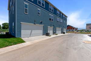 Back of house with a garage, board and batten siding, and stucco siding