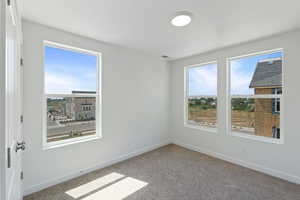 Empty room featuring baseboards and carpet floors