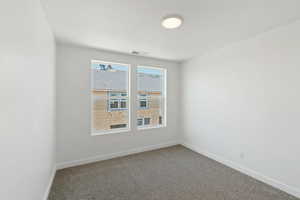 Carpeted spare room with baseboards