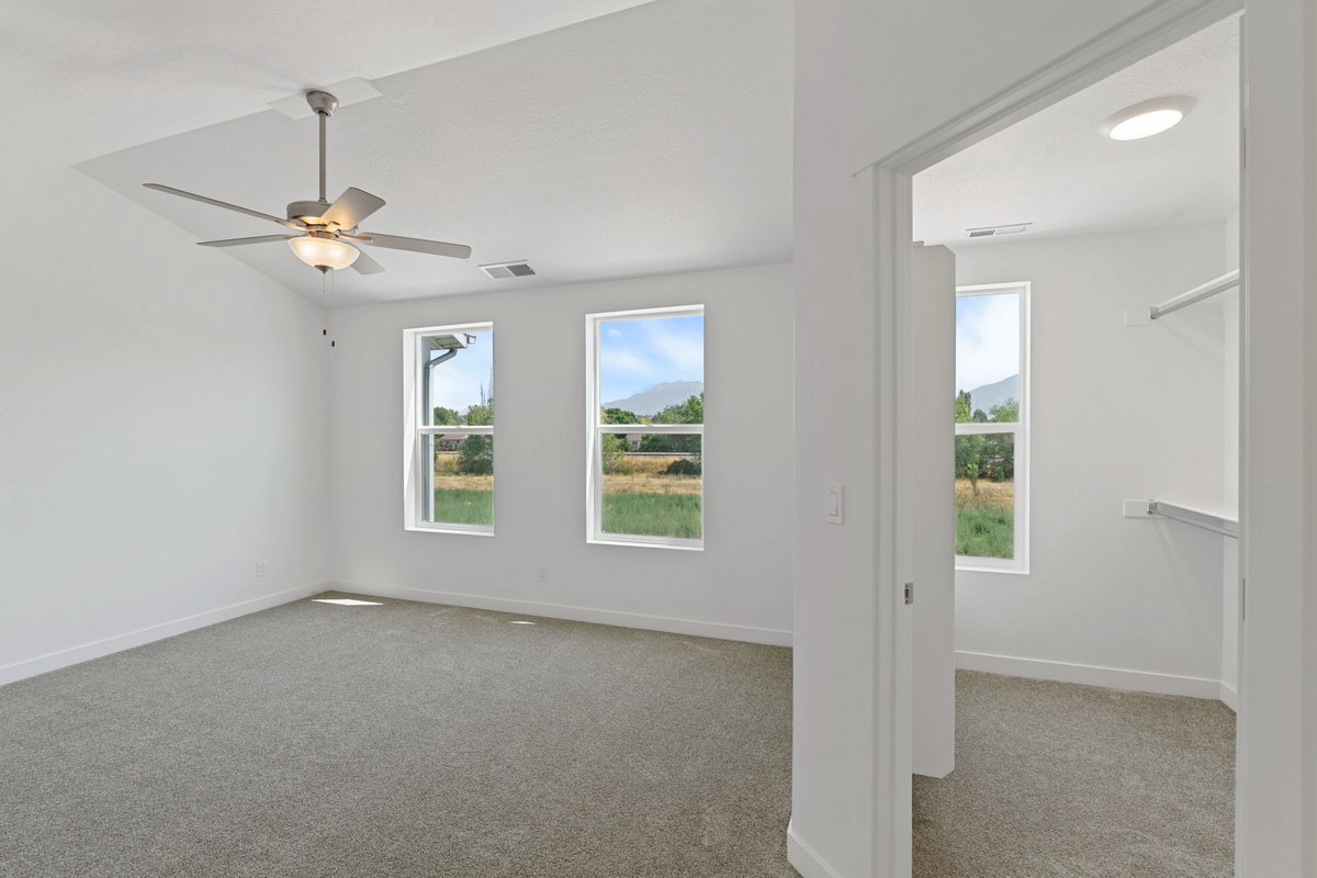 Empty room featuring carpet and a ceiling fan