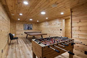 Playroom with recessed lighting, wooden walls, light wood-style floors, and wood ceiling