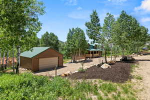 View of yard featuring a detached garage and an outdoor structure