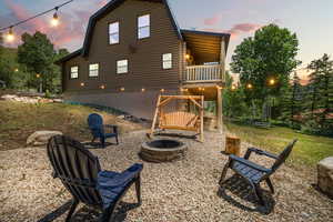 Back of house featuring a fire pit and a gambrel roof