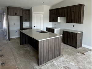 Kitchen featuring a textured ceiling, a spacious island, vaulted ceiling, and modern cabinets