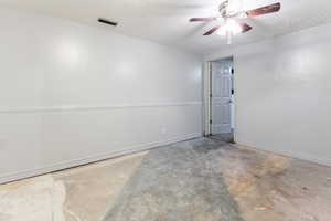 Large room with concrete flooring and ceiling fan