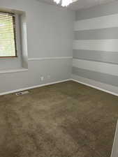 Unfurnished room featuring dark colored carpet and a textured ceiling