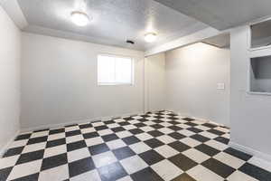 Bedroom featuring a textured ceiling, a textured wall, and vinyl patterned floors