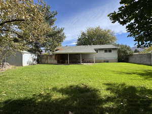 Back of house with a shed, a fenced backyard, and a patio area