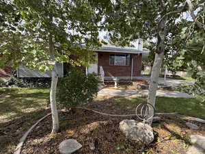 Rear view of property featuring brick siding, a chimney, and covered porch