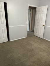 Carpeted empty room with baseboards