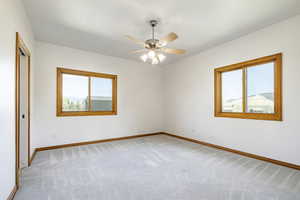 Unfurnished room featuring light carpet and ceiling fan