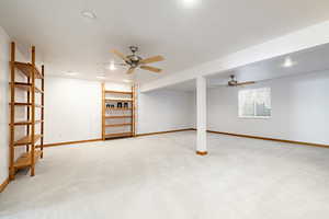 Below grade area featuring light carpet and ceiling fan