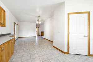 Kitchen with a ceiling fan, brown cabinets, light countertops, and light tile patterned floors