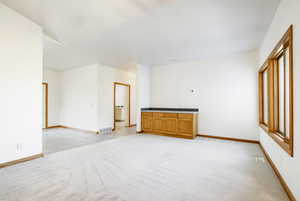 Spare room with light carpet and baseboards