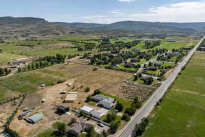 Aerial overview of property's location featuring a mountain backdrop and rural landscape
