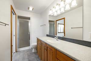 Full bath featuring a chandelier, vanity, a stall shower, and tile patterned floors