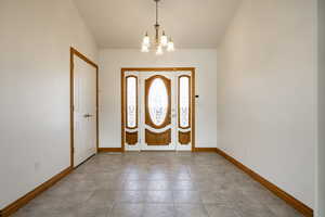 Entrance foyer with a chandelier and light tile patterned floors