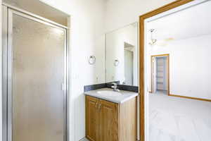 Full bathroom featuring a stall shower, vanity, and ceiling fan