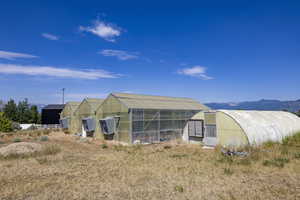 Back of house with an exterior structure, an outbuilding, and a mountain view