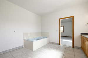 Bathroom featuring vanity, a bath, and tile patterned flooring