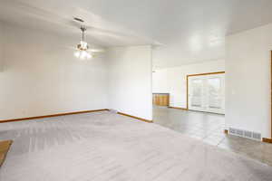 Tiled empty room with carpet floors and a ceiling fan